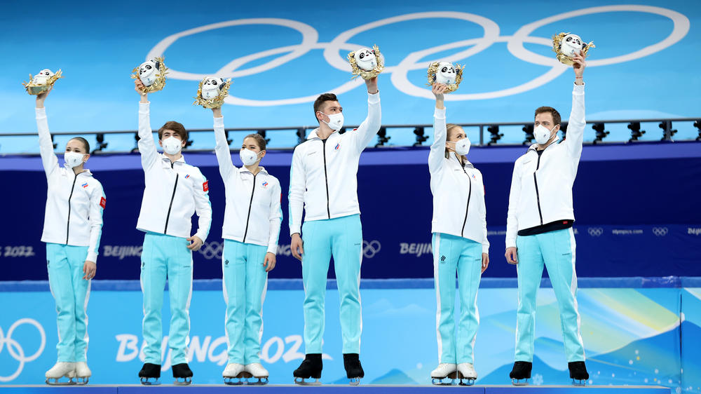 Russia figure skaters celebrate their win in the team event, but that gold medal is now in doubt because of questions about Kamila Valieva's eligibility.