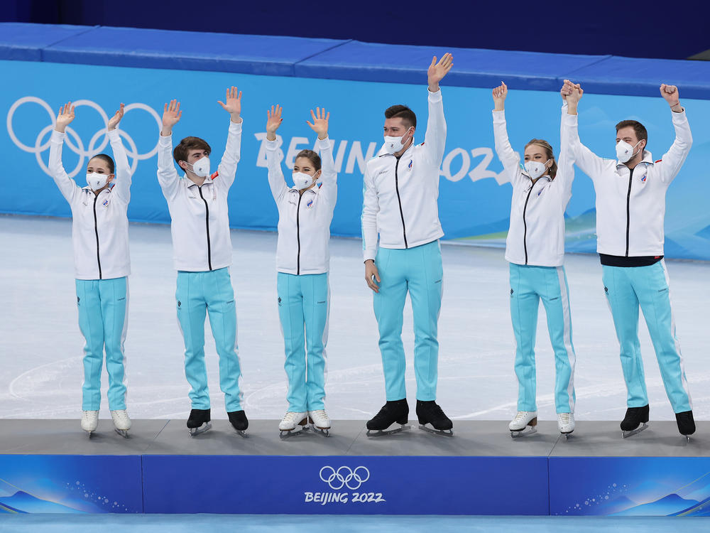 Kamila Valieva (L) and the rest of Team ROC celebrate their gold medal performance during the the Team Event flower ceremony on February 7, 2022 at the Beijing Winter Olympics.