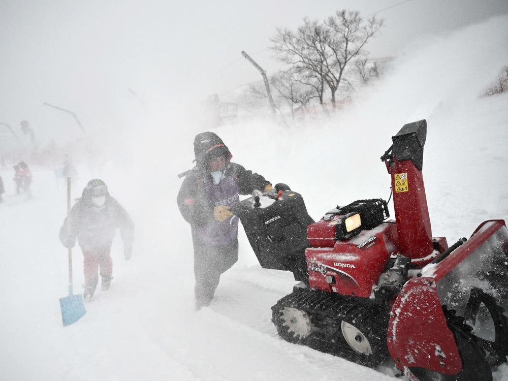 Crew members prepare the course as snow falls ahead of the first run of the men's giant slalom during the Beijing 2022 Winter Olympic Games on Feb. 13.