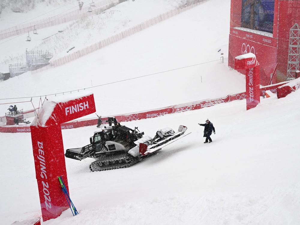 Workers clear snow from the finish line prior to the second run of the men's giant slalom. The second run was delayed due to the heavy snowfall.