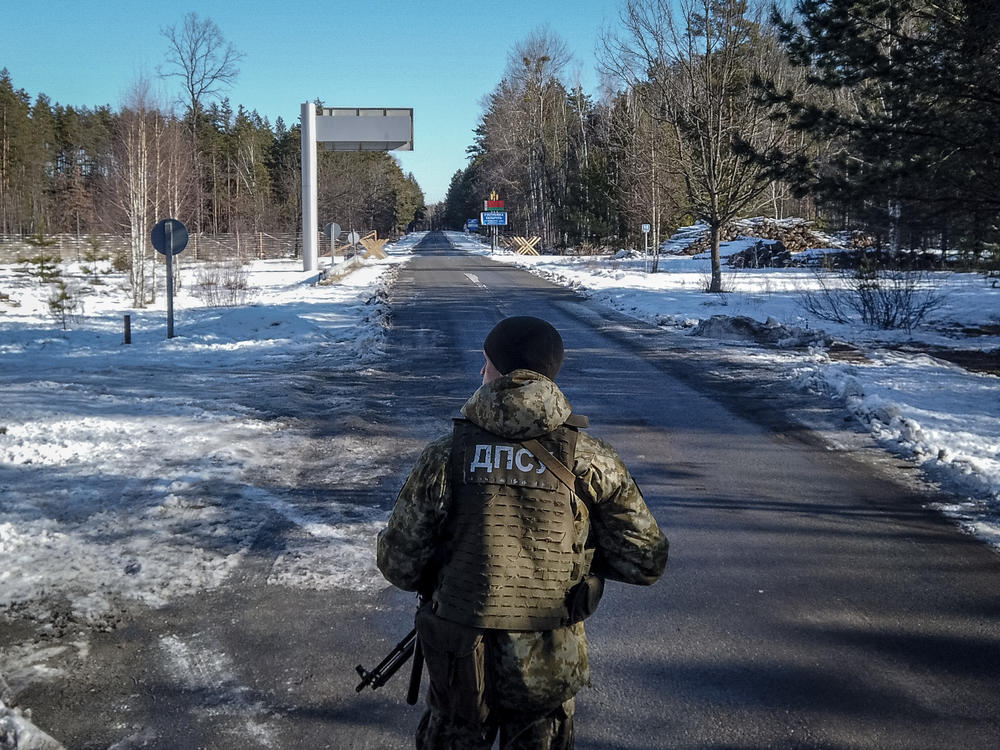 A member of the Ukrainian State Border Guard stands watch at the border crossing between Ukraine and Belarus on Saturday.