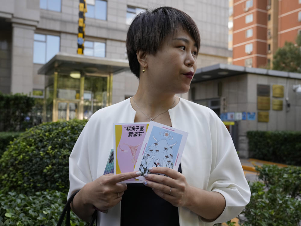Teresa Xu holds up cards, one of which reads 