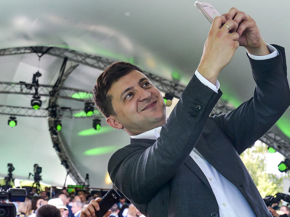 Ukrainian President Volodymyr Zelenskyy takes a selfie at the first congress of his party called Servant of the People in the city Botanical Garden, Kiev, Ukraine, Sunday, June 9, 2019.