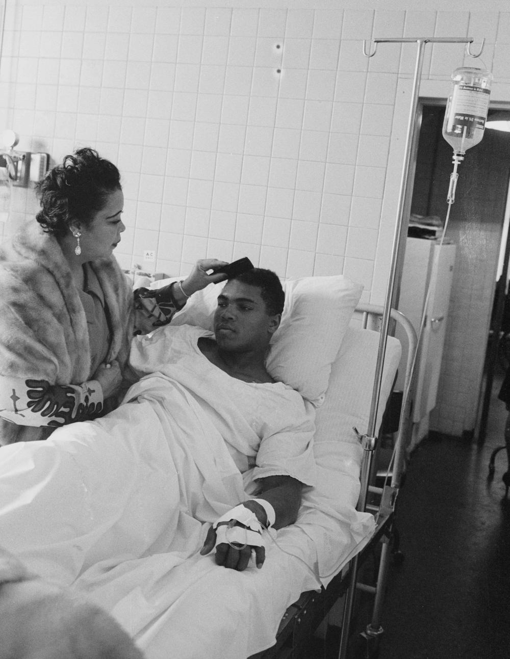 Muhammad Ali's mother, Odessa O'Grady Clay, visits the boxer in a Boston hospital as he recuperates from the hernia operation that forced postponement of his rematch with Joe Frazier. Ted Polumbaum surrendered a roll of unexposed film to Ali's guards and got the picture to LIFE magazine.