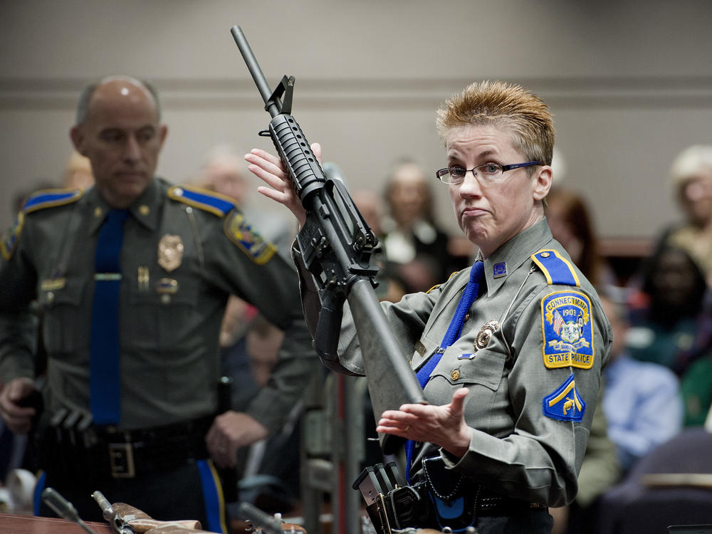 Firearms training unit Detective Barbara Mattson, of the Connecticut State Police, holds up a Bushmaster AR-15 rifle — the same make and model of the gun used in the Sandy Hook School shooting.