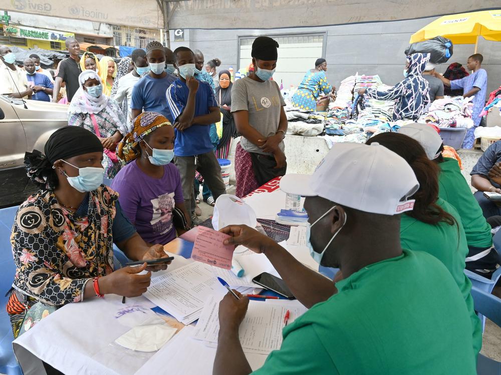 People line up to receive a Pfizer COVID-19 vaccine dose during a mass vaccination campaign in Abidjan, Ivory Coast, in August 2021.