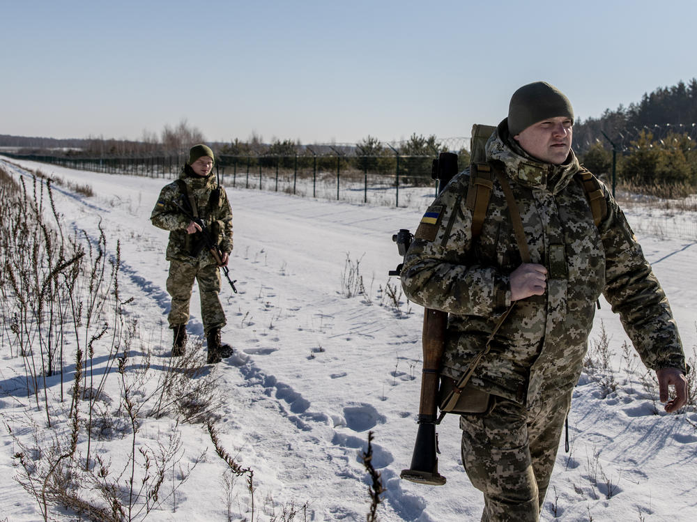 Members of the Ukrainian Border Guard patrol along the Ukrainian border fence at the Three Sisters border crossing between Ukraine, Russia and Belarus on Monday.
