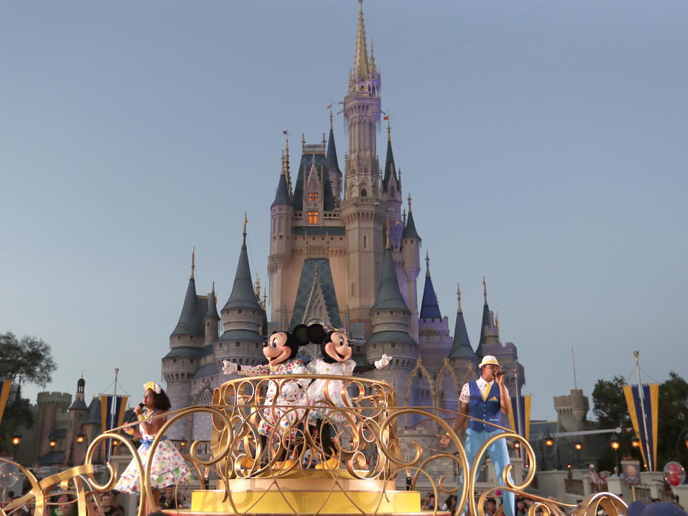 Mickey and Minnie Mouse perform during a parade as they pass by the Cinderella Castle at the Magic Kingdom theme park at Walt Disney World in Florida. The theme park resort announced Tuesday that face coverings will be optional for fully vaccinated visitors in all indoor and outdoor locations.