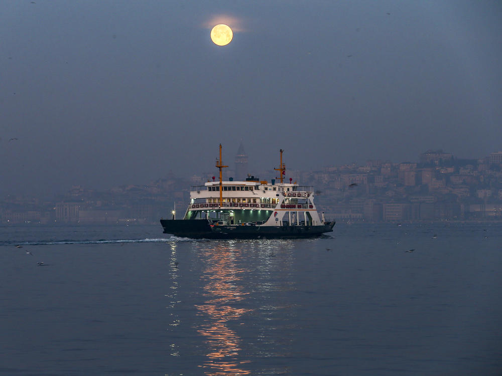 The full moon sets over the Bosphorus in Istanbul on Wednesday.