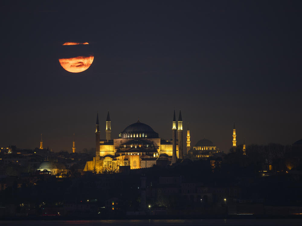 The moon appears over the Hagia Sophia and Suleymaniye Mosque in Istanbul on Tuesday.