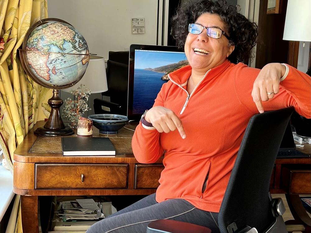 Heidi Brooks, senior lecturer in organizational behavior at the Yale School of Management, points to the chair she discovered was missing from her office on campus. Then she remembered it's been in her home office since she brought it home at the start of the pandemic.