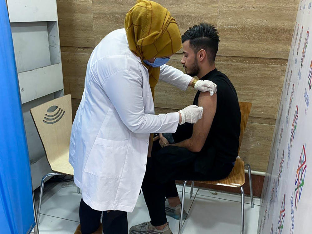 Hussein Raad, a 22-year-old college student, gets his second dose of the Pfizer vaccine at Zayoona Mall in Baghdad.