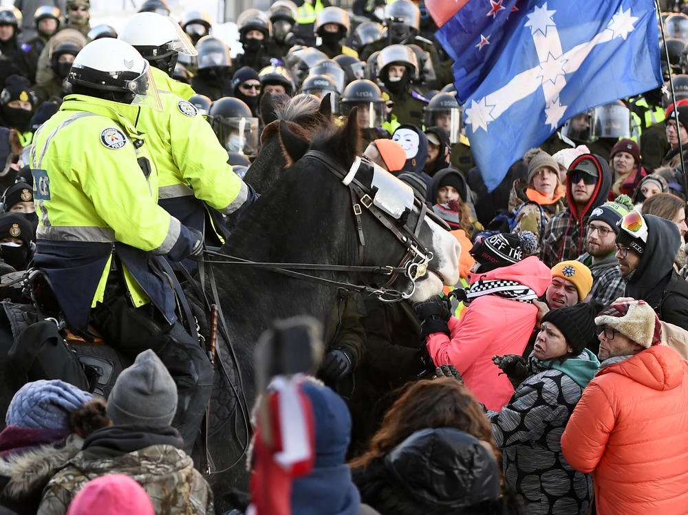 A mounted unit tries to disperse a crowd on Friday as police take action to put an end to a protest, which started in opposition to mandatory COVID-19 vaccine mandates and grew into a broader anti-government demonstration and occupation in Ottawa.