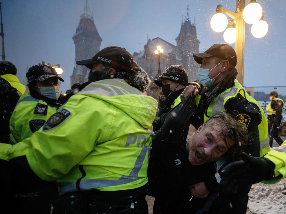 A man is arrested by police in Ottawa on Thursday as demonstrators and supporters gather in a protest against COVID-19 measures that has grown into a broader anti-government protest.