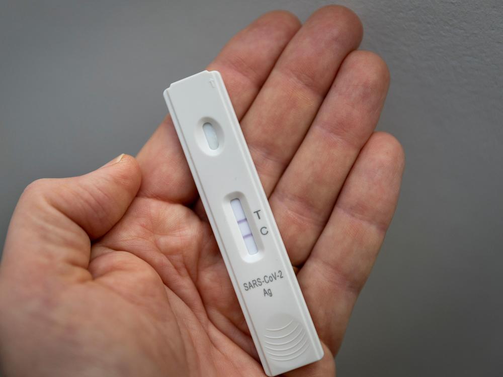 A rapid antigen test shows a positive test result for COVID-19.