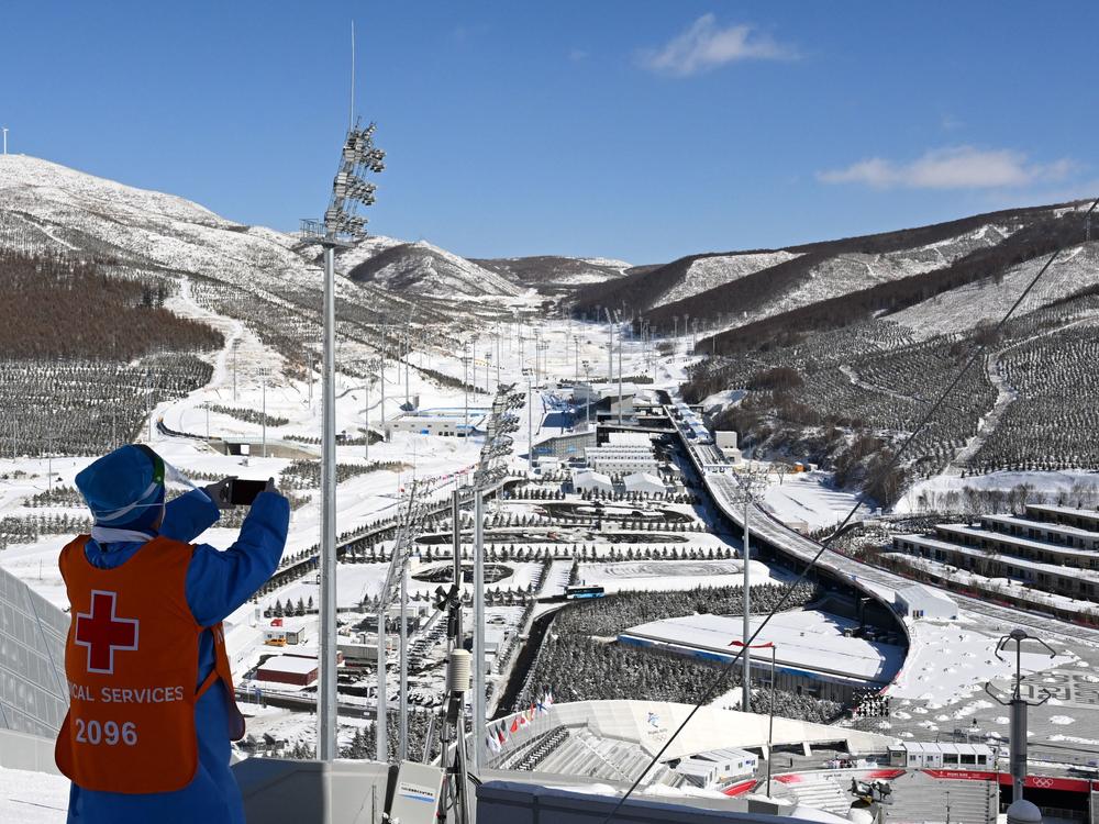 A medical helper takes a photo of the Zhangjiakou National Ski Jumping Center during the Winter Olympics on Feb. 14.