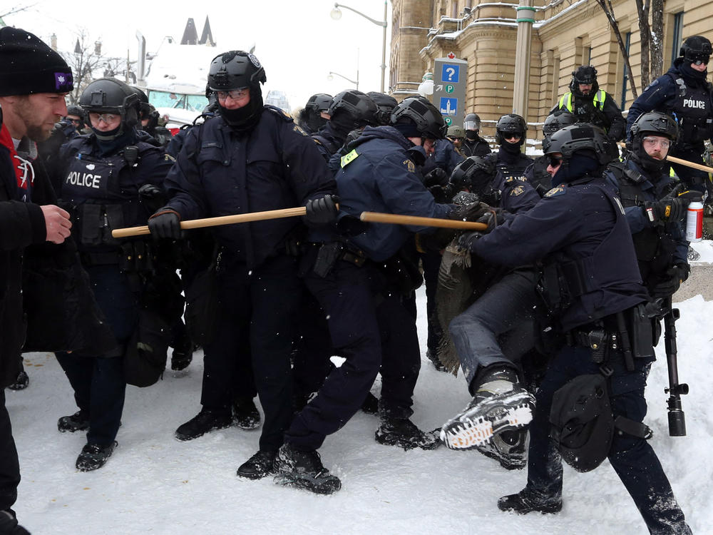 Police push protesters back on Saturday in Ottawa, the Canadian capital. After making more than 100 arrests on Friday, police resumed their work to clear the protesters who oppose many of Canada's COVID-19 restrictions.