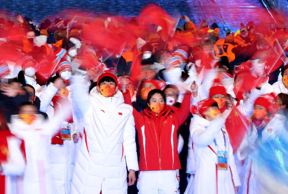 Members of Team China wave flags as they walk in the athletes parade during the closing ceremony of the 2022 Beijing Olympic Games.