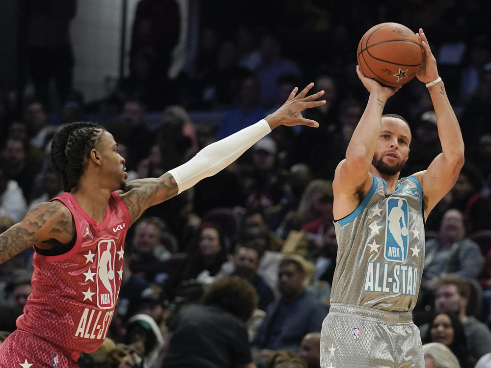 Golden State Warriors' Stephen Curry (right) shoots for 3 as Memphis Grizzlies' Ja Morant defends during the second half of the NBA All-Star basketball game on Sunday in Cleveland.