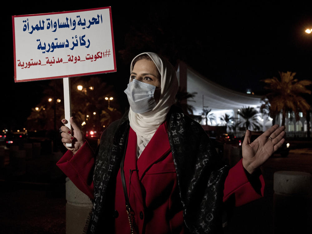 Mashael al-Shuwaihan, who sits on the board of Kuwait's Women's Cultural Society, speaks during an interview, at a protest outside Kuwait's National Assembly in Kuwait City on Feb. 7, 2022. Her placard reads: 