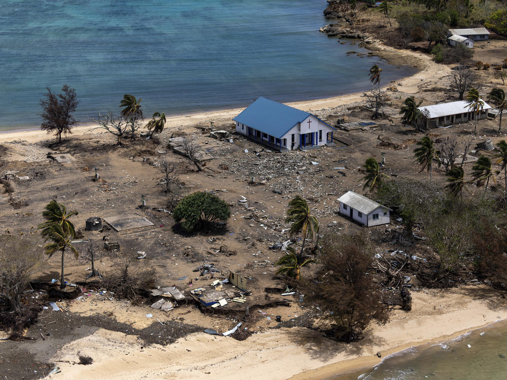 In this photo provided by the Australian Defence Force, debris from damaged building and trees are strewn around on Atata Island in Tonga, on Jan. 28, 2022, following the eruption of an underwater volcano and subsequent tsunami.