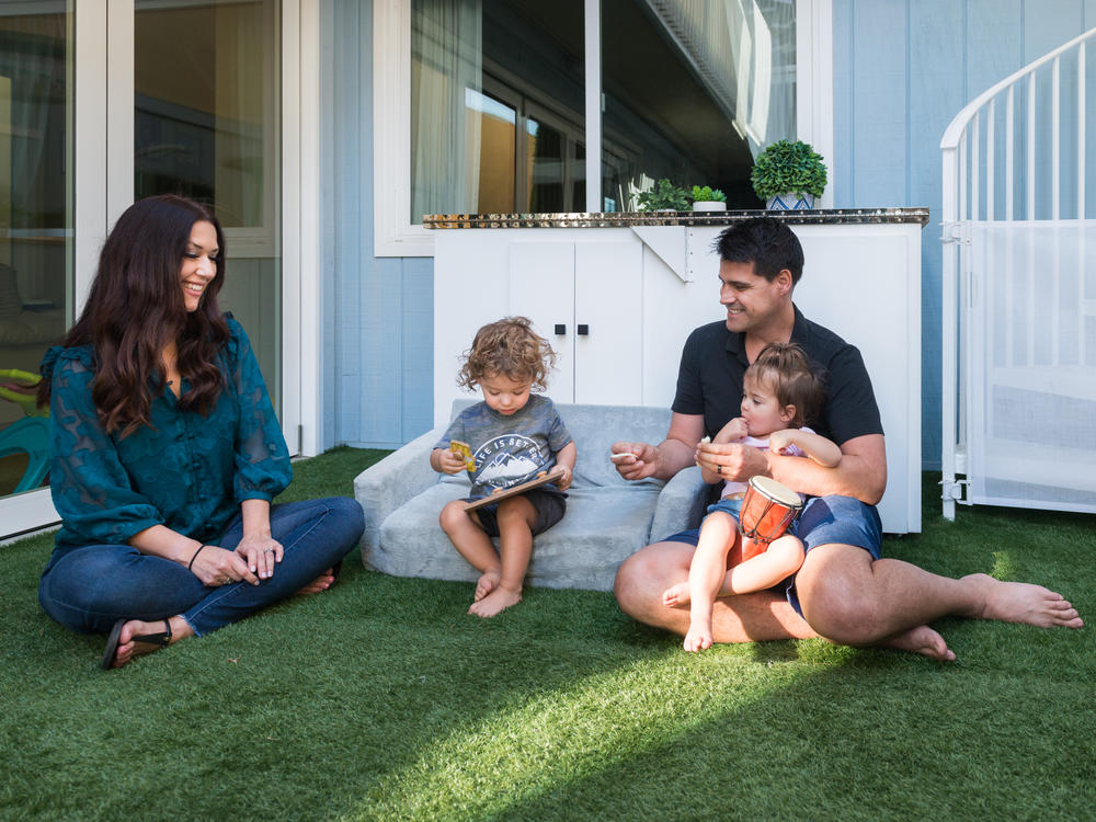 Sugar and Greg Bull play with their twins, Redford and Scarlett, who were born prematurely in 2020. Their insurance company initially said the births were not an emergency, and the family ended up with bills totaling more than $80,000.