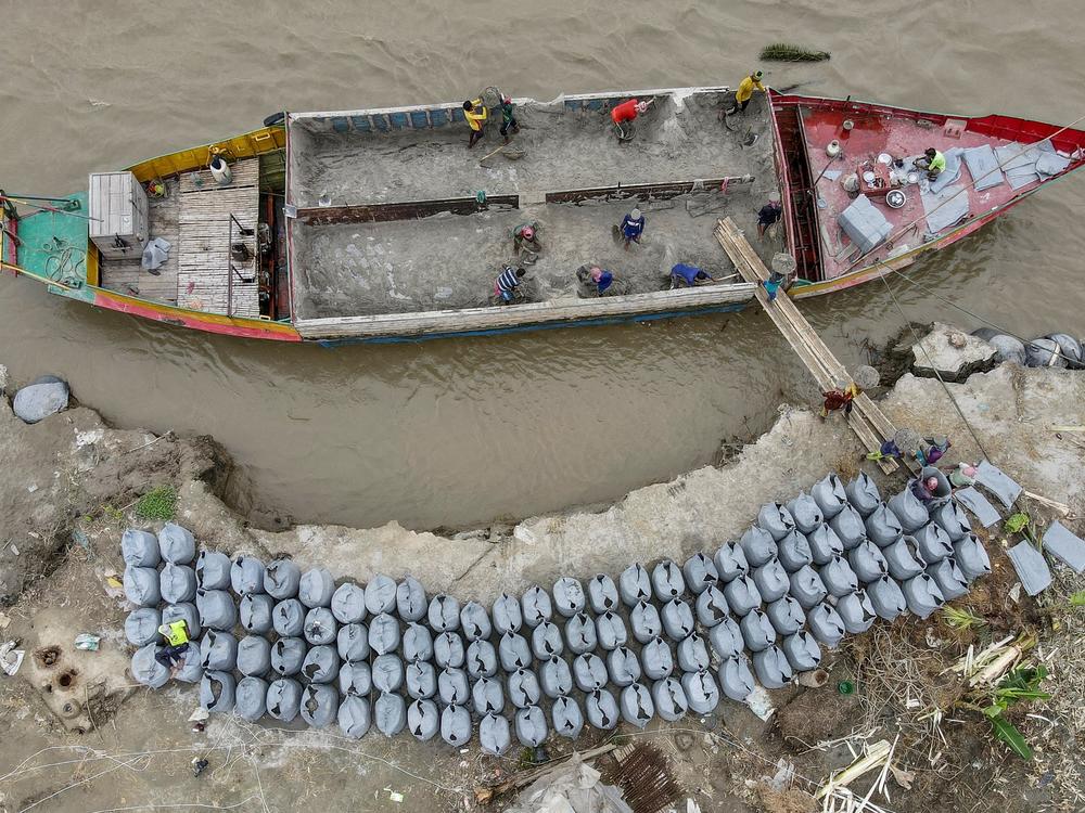 Workers place geo-textile bags to prevent river erosion on the banks of Padma River in Bangladesh last September.