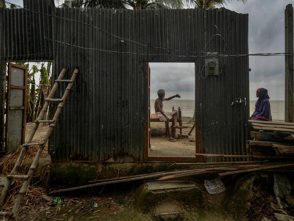 An elderly man sits and talks at his home last September after relocating due to the threat caused by the river erosion on the banks of the Padma River in Manikganj, Bangladesh.