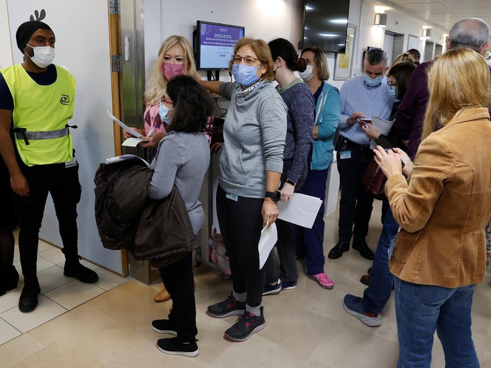 Staff volunteers queue to receive a fourth dose of the Pfizer COVID-19 vaccine at Sheba Medical Center in Israel on Dec. 27, 2021, as the hospital conducted a trial of a fourth jab of the vaccine.