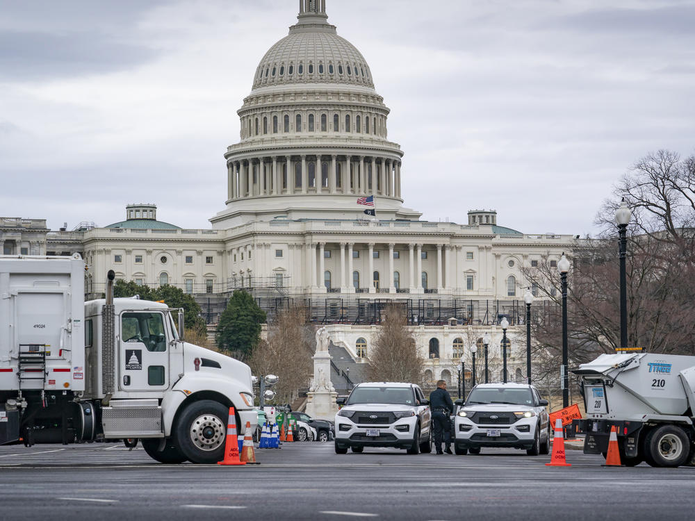 Heavy vehicles, including garbage trucks and snow plows, are set near the entrance to Capitol Hill at Pennsylvania Avenue and 3rd Street NW in Washington on Tuesday.