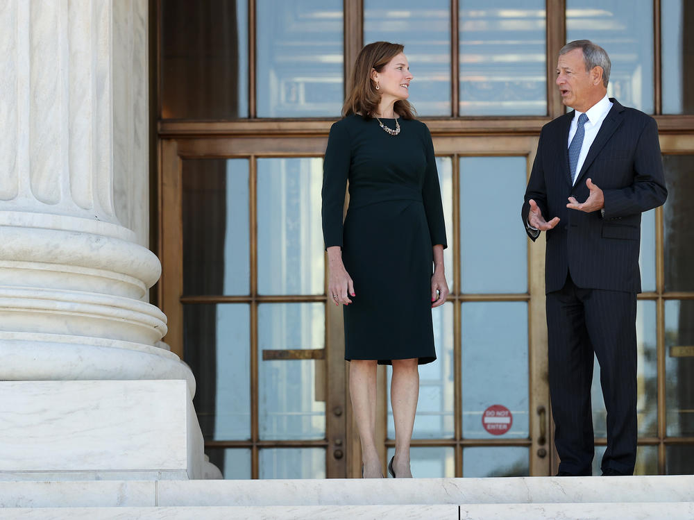 U.S. Supreme Court Associate Justice Amy Coney Barrett and Chief Justice John Roberts in October. When the Supreme Court gutted a key part of the voting rights law eight years ago, Roberts said laws must pertain to current circumstances. Barrett is part of the court's conservative majority.