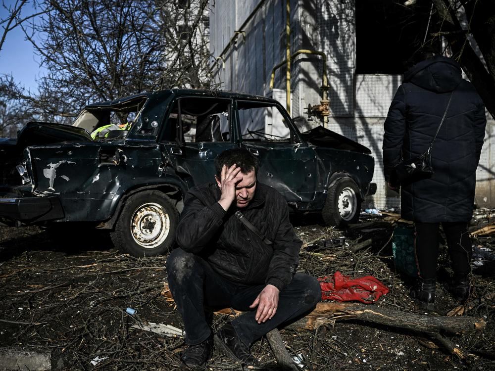 A man sits outside his destroyed building following bombings that hit the eastern Ukraine town of Chuhuiv on Thursday as Russian armed forces are trying to invade Ukraine from several directions, the border guard service said.