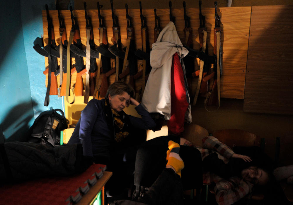 People hide in a bomb shelter in Kyiv in the early hours of February 25, 2022. Invading Russian forces pressed deep into Ukraine as deadly battles reached the outskirts of Kyiv, with explosions heard in the capital early Friday that the besieged government described as 