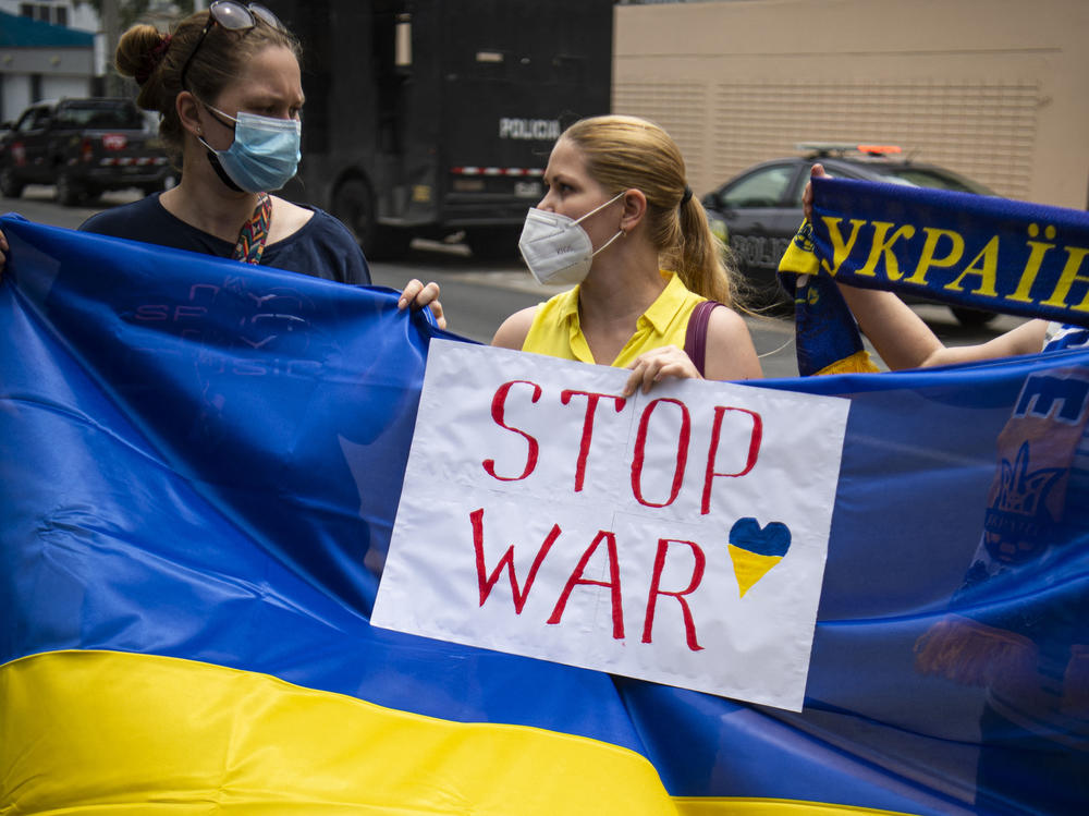 Ukrainian citizens hold posters and national flags during a demonstration in support of Ukraine outside the Russian Embassy in Lima, Peru, on Friday.