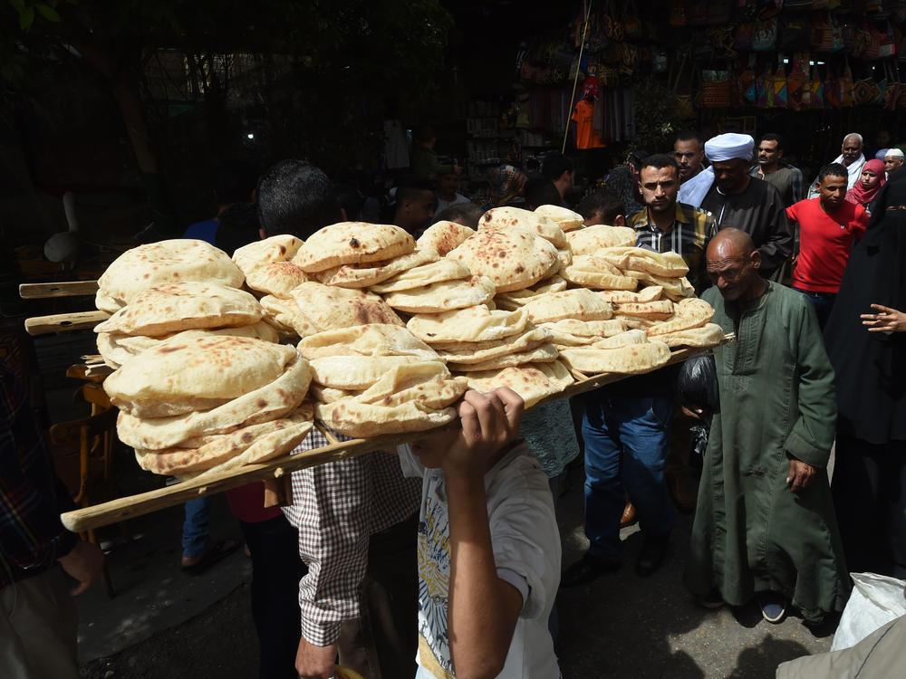 A bread seller walks in the open air market in central Cairo in 2018.