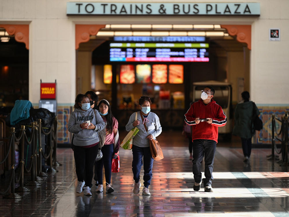 A masked-up family walks through Union Station in Los Angeles in early January. Nearly two months later numerous states and cities have dropped their mandates.