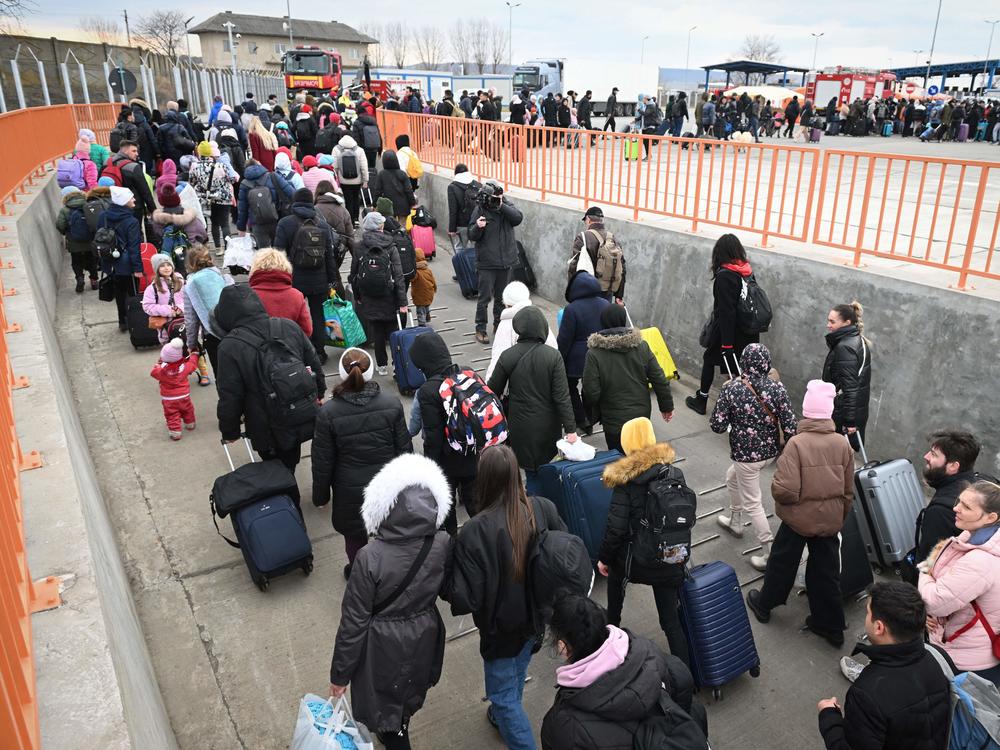 People coming from Ukraine descend from a ferry boat to enter Romania at the Isaccea-Orlivka border crossing at the Danube river.