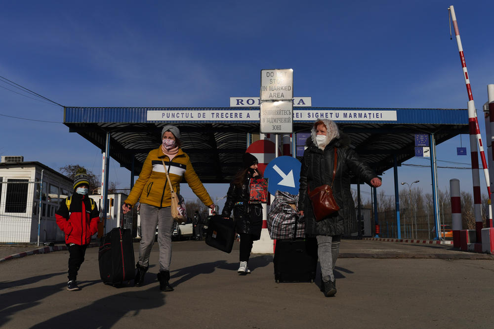 A family walks away from the war-torn Ukraine and into Romania on Friday.