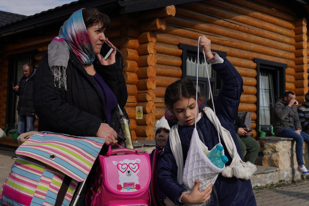 A woman talks on the phone to organize accommodations in Sighetu Marmatiei, Romania, after having crossed from Ukraine.