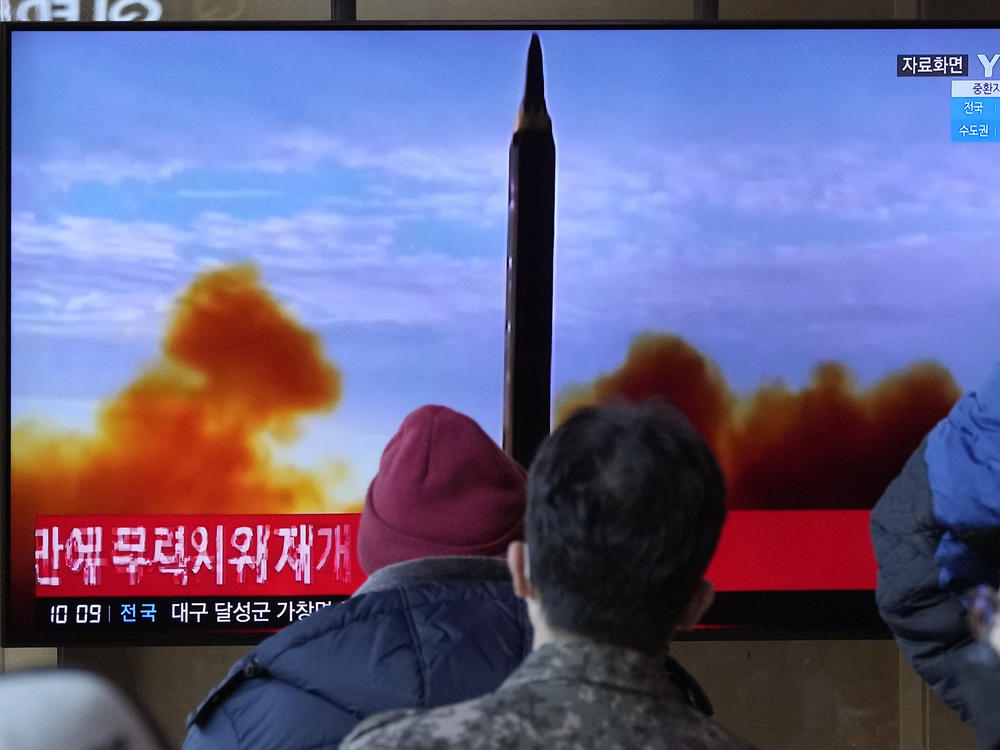 People at the Seoul Railway station watch a TV showing a file image of North Korea's missile launch during a news program on Sunday, Feb. 27, 2022.