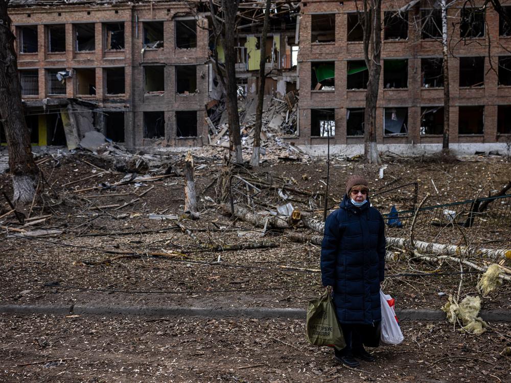 A woman stands in front of a destroyed building after a Russian missile attack in the town of Vasylkiv, near Kyiv, on  Sunday. Russian forces faced stiff resistance over the weekend and faced logistics problems in their invasion plans.