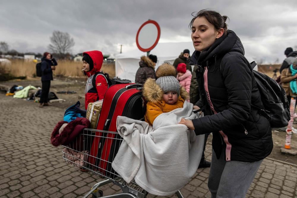 A mother and her child are among the Ukrainians at the Medyka pedestrian border crossing on Sunday in Poland.