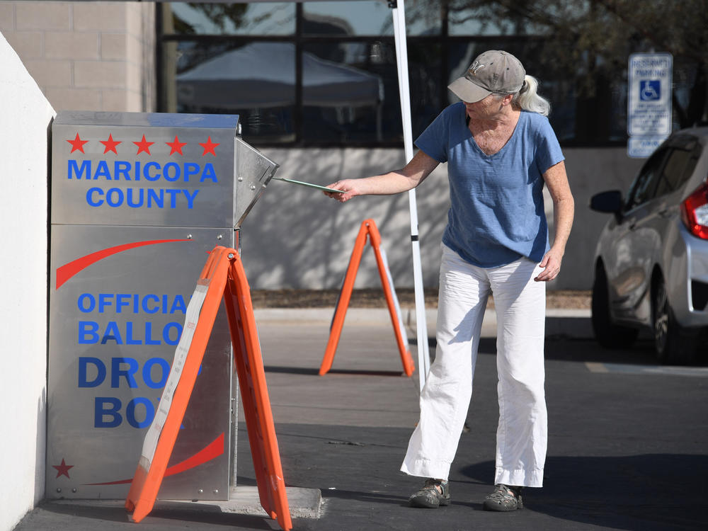People deposit their mail-in ballots for the U.S. presidential election at a ballot collection box in Phoenix on Oct. 18, 2020.