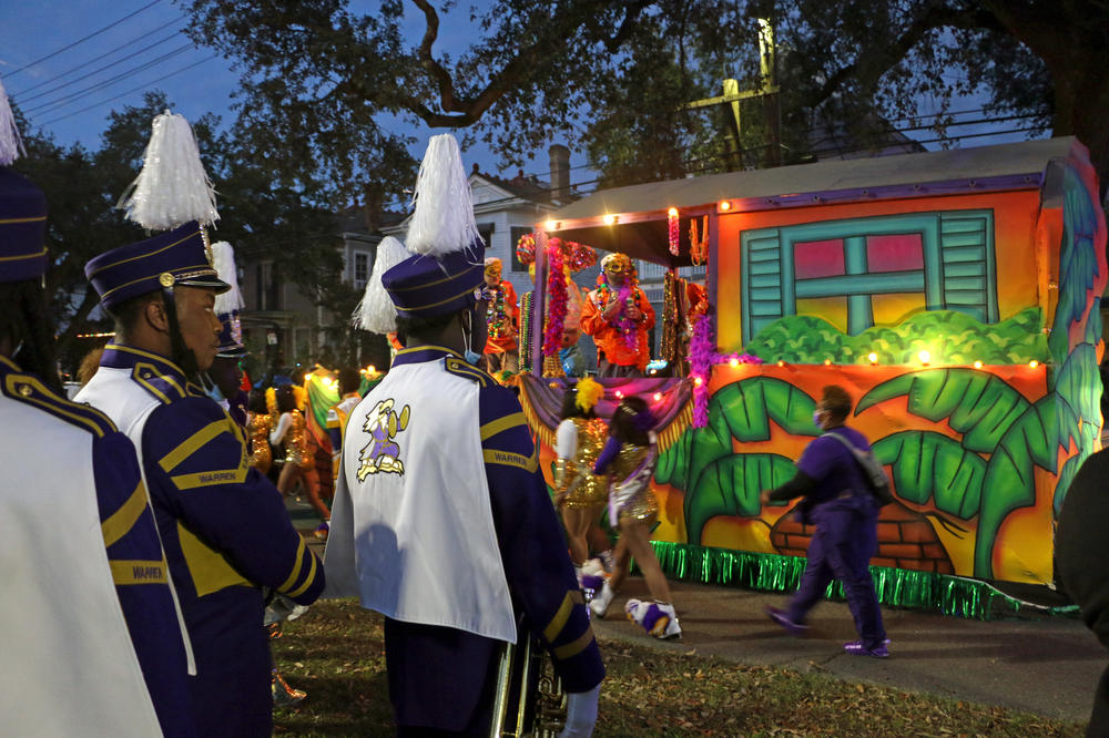 Members of the Warren Easton band watch as floats line up at the start of the parade route.
