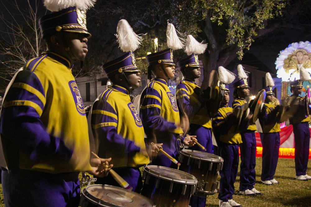 The snare drummers and cymbal players of Warren Easton battle another band while waiting for their first parade of the season to start.