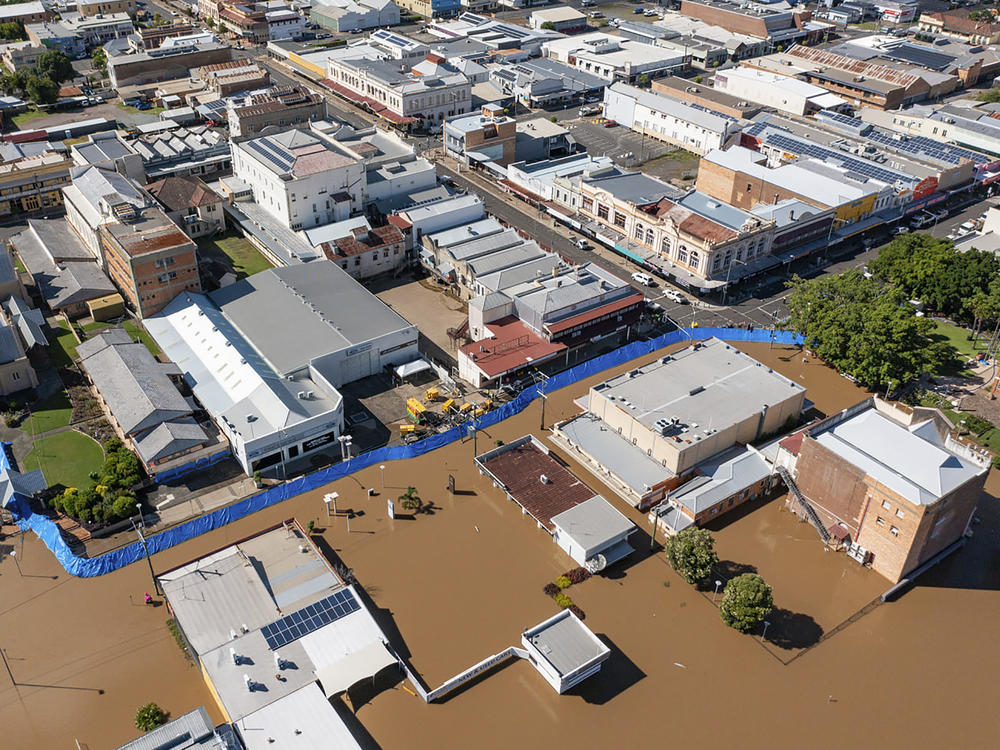 In this photo provided by the Fraser Coast Regional Council, a blue barrier helps hold back flood water in a section of Maryborough, Australia on Tuesday.