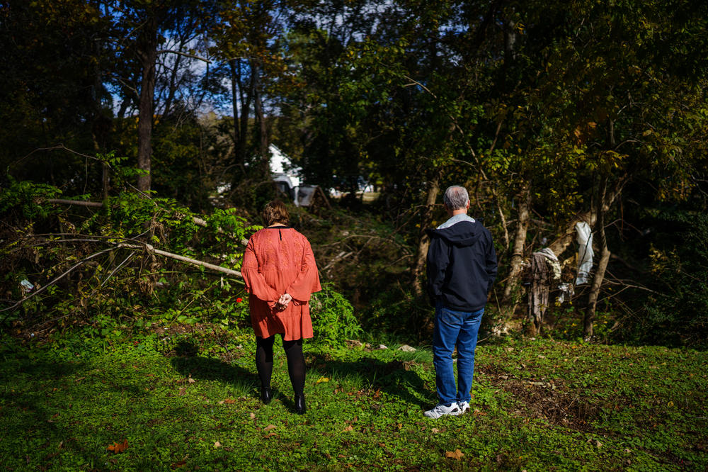 Gretchen Turner and her husband, Danny, stand in their backyard, looking at debris that remains in Trace Creek two months after floods tore through the area.