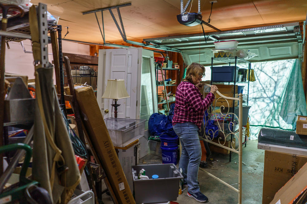 Gretchen Turner pulls a bed frame from the garage, where many of their household items have been stored since the flood.