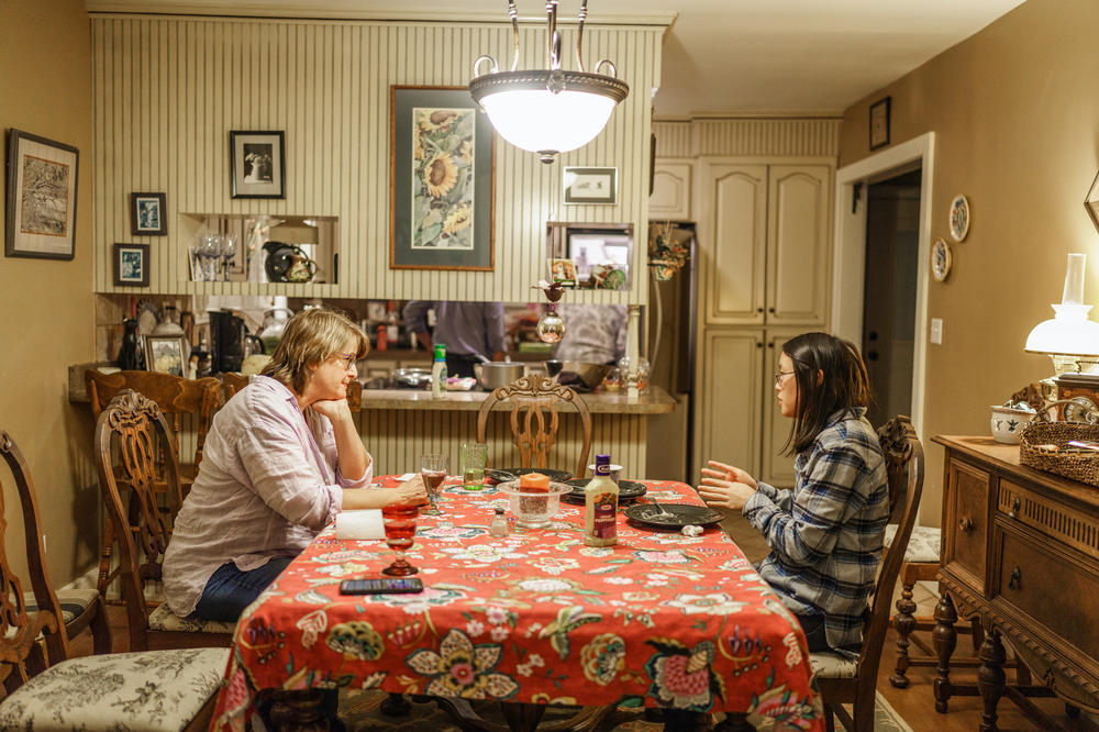 Gretchen Turner and her daughter, Zoe, talk at the dinner table after eating dinner in Gretchen's mother's home.