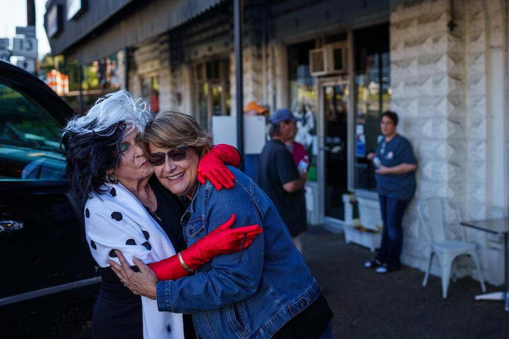 Neighbors Peggy Moore and Gretchen Turner embrace before the start of a Halloween event in downtown Waverly, Tenn. The two used to see each other every day before floods forced them from their homes, but now they see each other every couple of days.